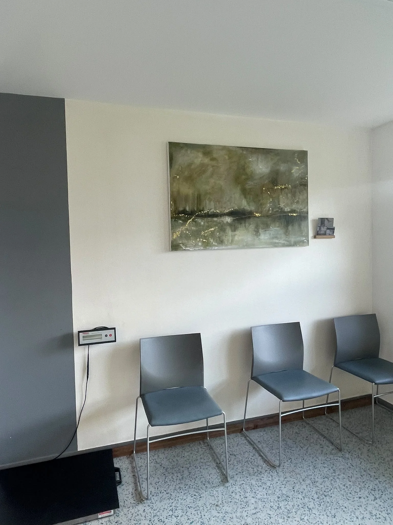 Wartebereich mit Sitzplätzen und großem Wandbild